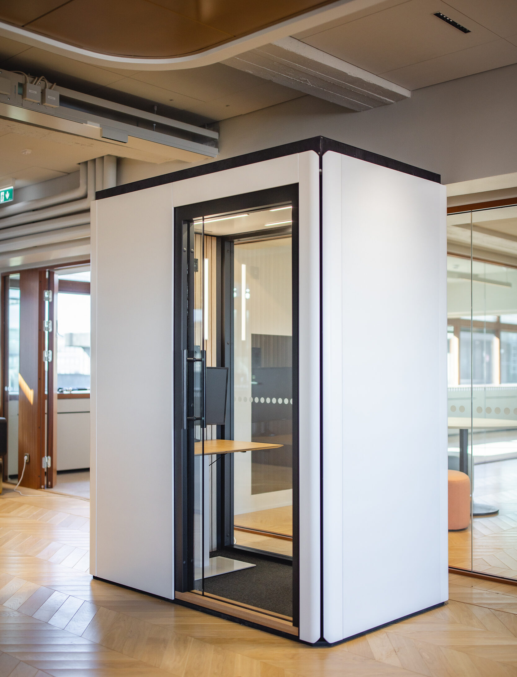 Octacell 2X1 phone booth in office setting with wood paneling