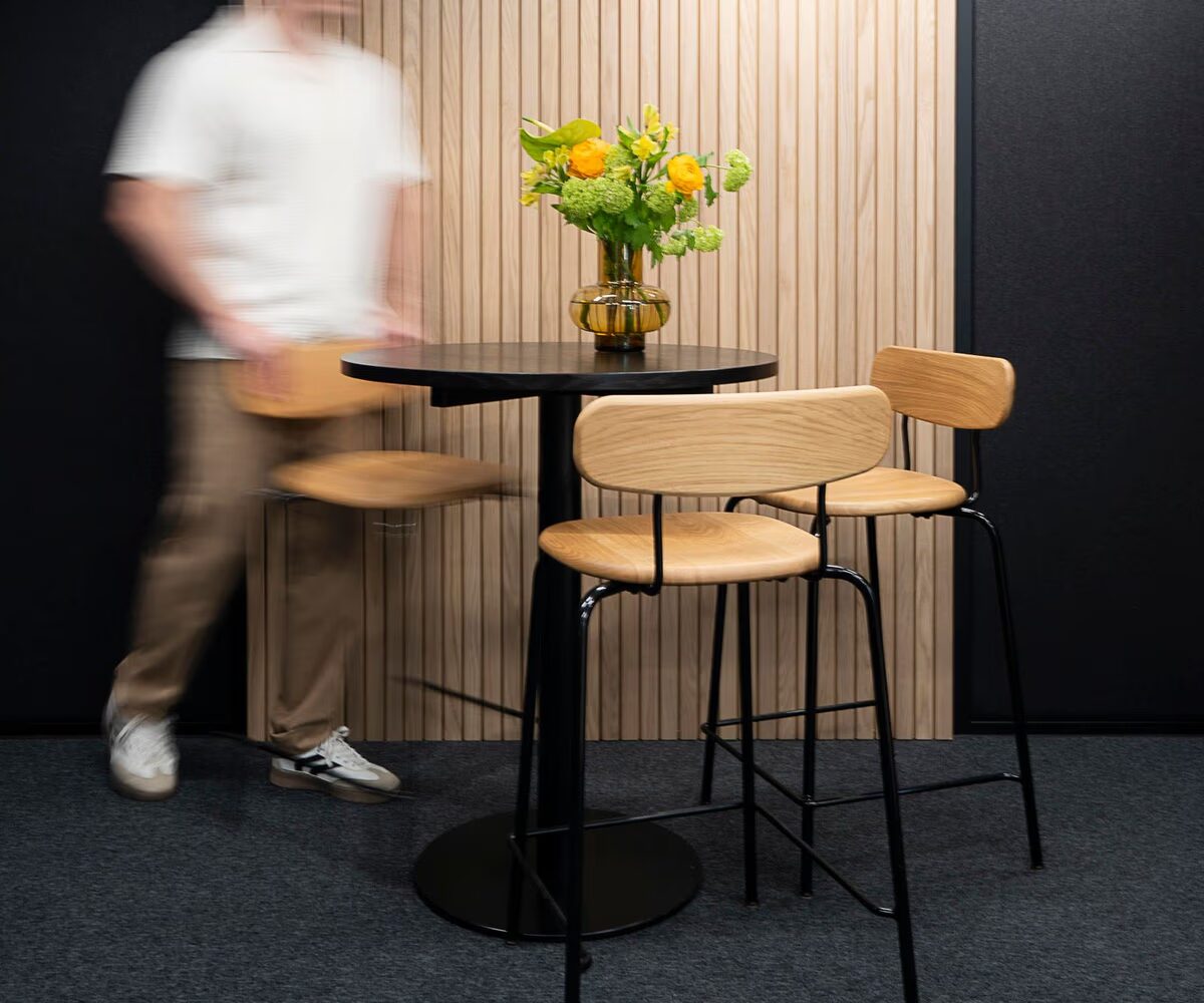 En person som lyfter en stol inuti en Octacell-arbetsrum