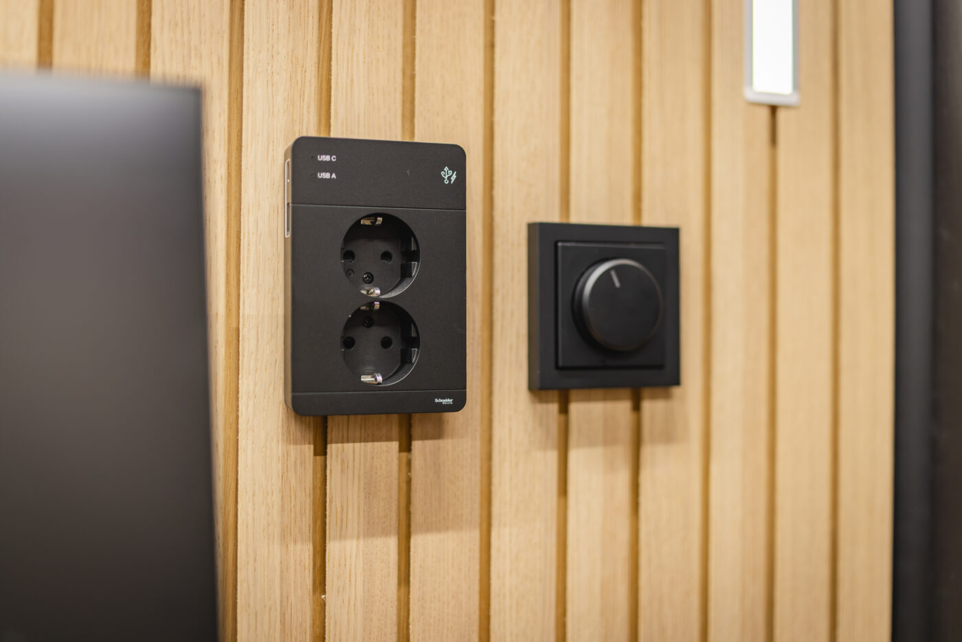 Power outlets, USB charging ports and a control dial inside an Octacell 2X2 workroom