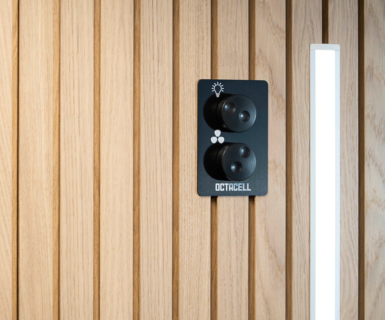 A close-up of light and ventilation dimmer switches mounted on the wall of an Octacell workroom