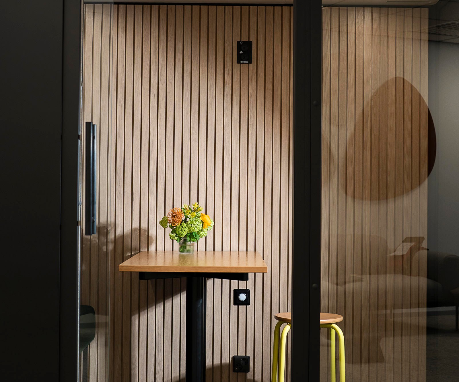 A vase with flowers on a desk in an Octacell workroom